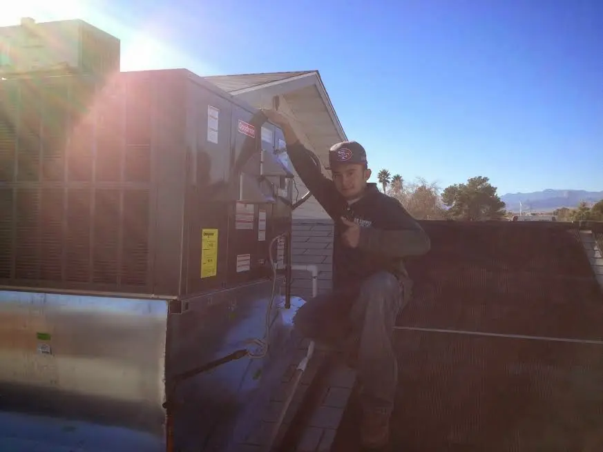 HVAC technician performing AC Tune-Up on a rooftop unit in Aberdeen